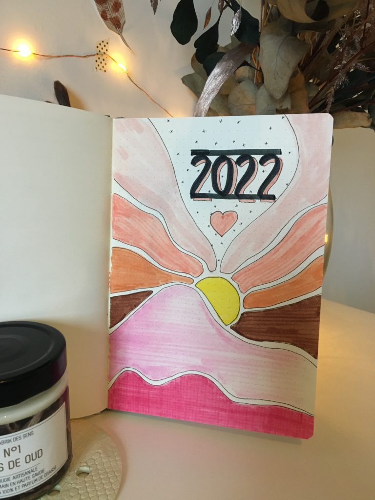 Photo d'une illustration de bullet journale 2022 avec des montagnes rosées.